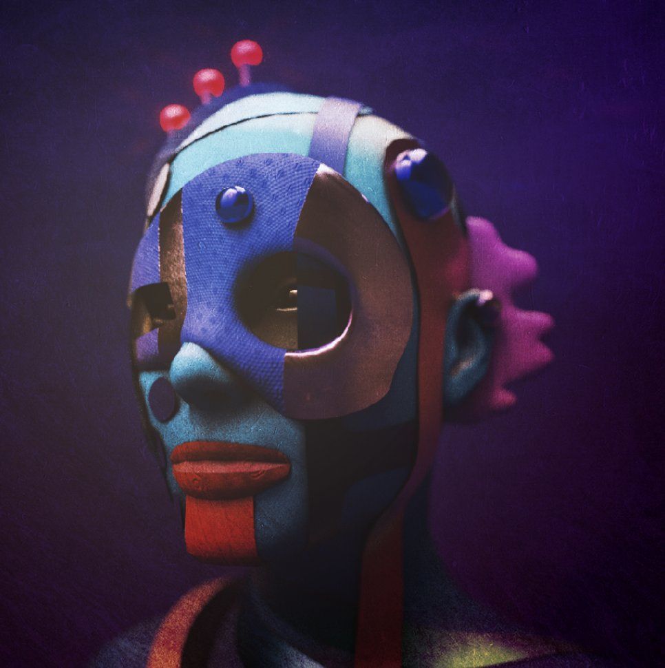 A sculpted head of a figure with a purple, red and blue geometric face and antenna-like ornaments
