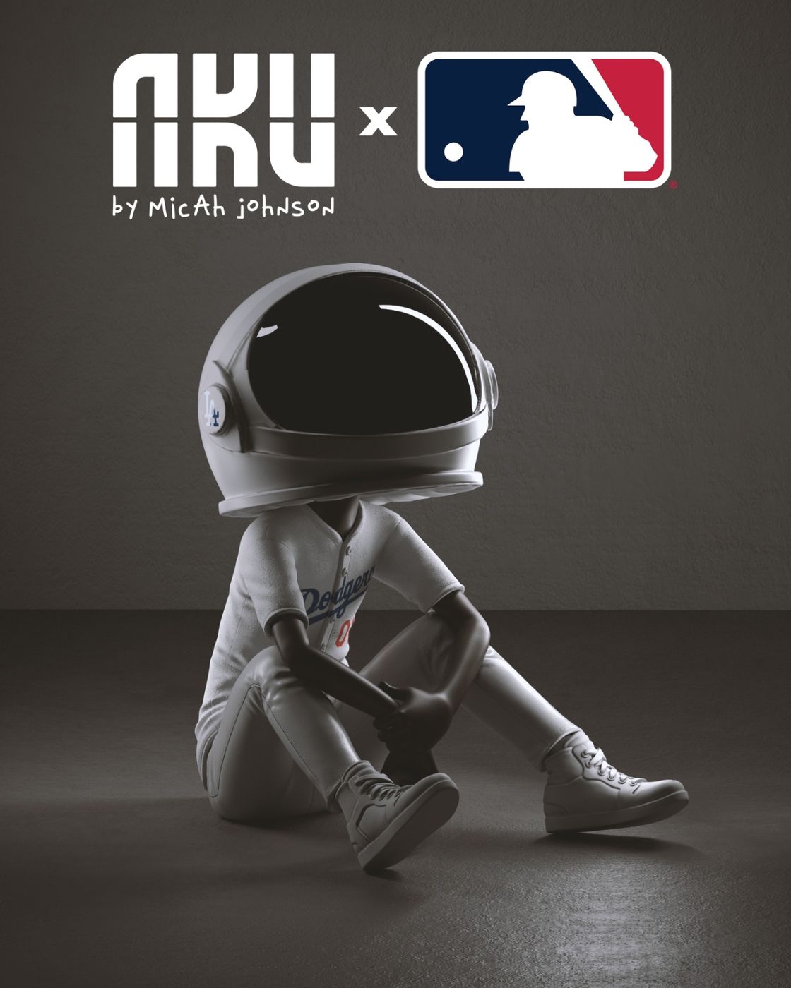 AKU × MLB — Aku in a white spacesuit and helmet sitting on the floor against a grey backdrop